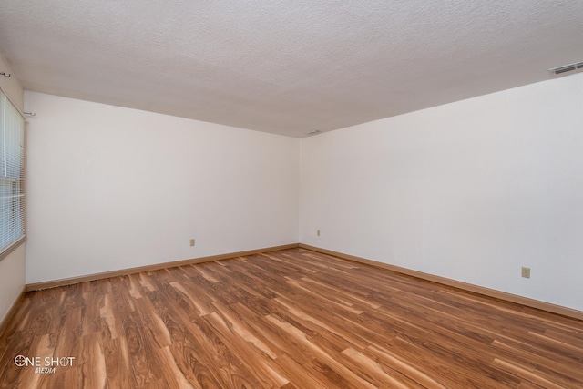 spare room with hardwood / wood-style flooring and a textured ceiling