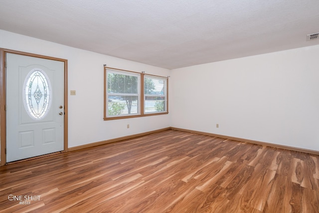 foyer entrance featuring hardwood / wood-style floors and a textured ceiling