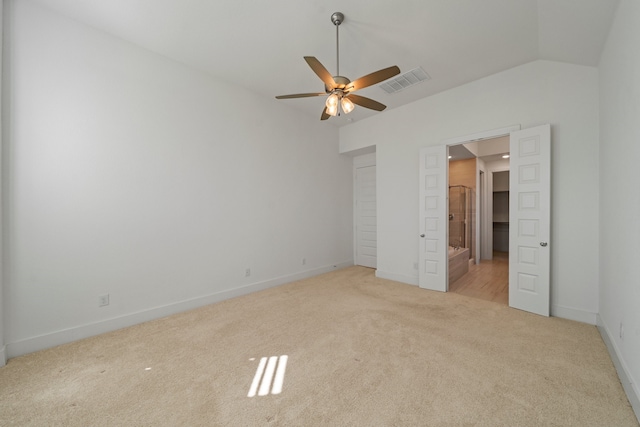 unfurnished bedroom featuring ceiling fan, lofted ceiling, and light colored carpet