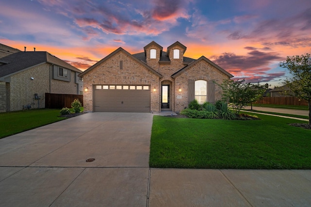 french country inspired facade with a yard and a garage