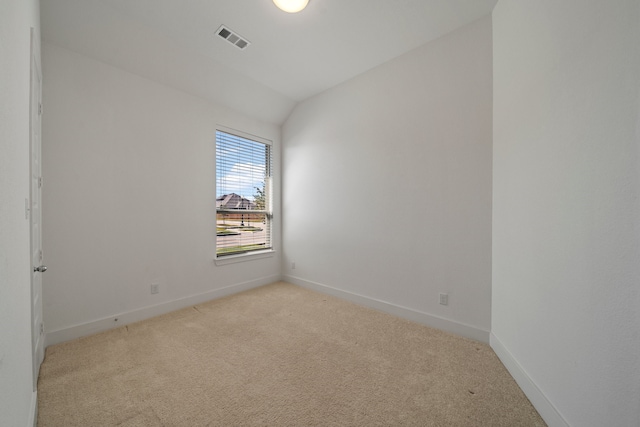 carpeted spare room featuring lofted ceiling