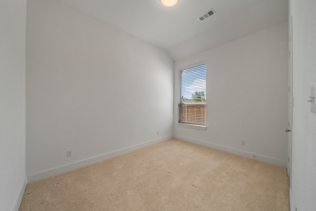 carpeted empty room featuring lofted ceiling