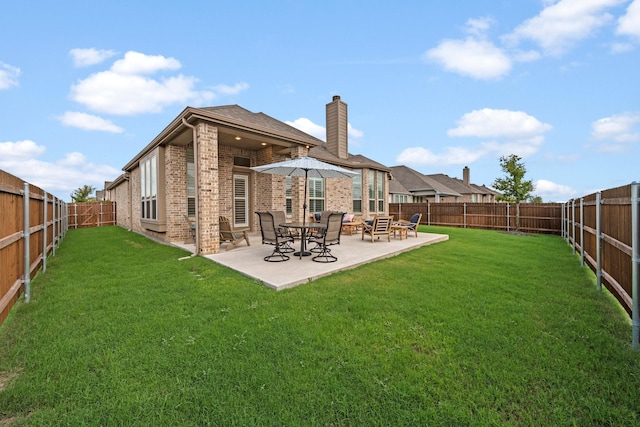 rear view of house featuring a patio and a lawn