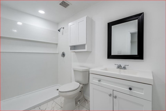 bathroom with a shower, vanity, tile patterned flooring, and toilet