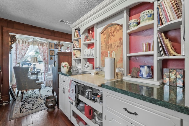 kitchen featuring dark hardwood / wood-style floors, white cabinetry, and a textured ceiling