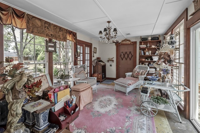 sunroom featuring a healthy amount of sunlight and a chandelier