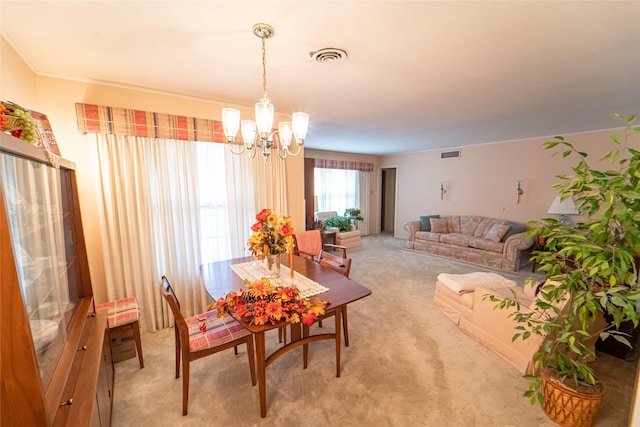 carpeted dining space with a chandelier