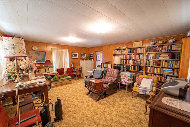 living area featuring carpet and wood walls