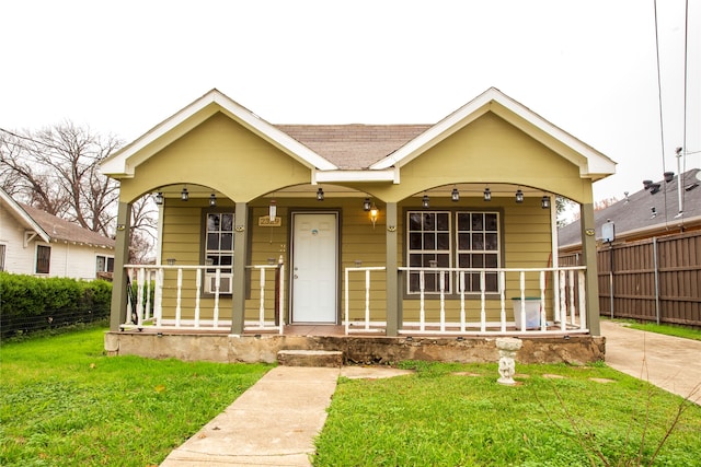 bungalow-style house with covered porch, a front lawn, and ceiling fan