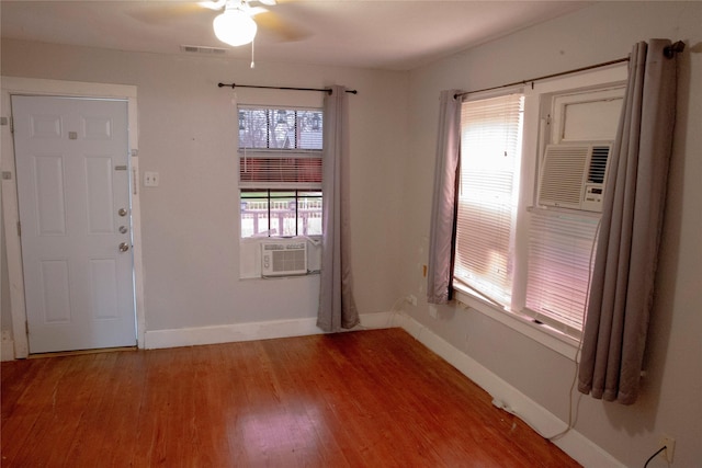 foyer with cooling unit, ceiling fan, and hardwood / wood-style floors