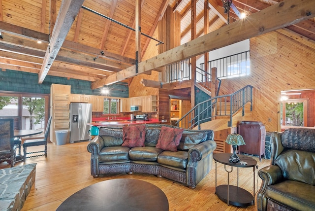 living room featuring beamed ceiling, light hardwood / wood-style floors, wood walls, and wooden ceiling