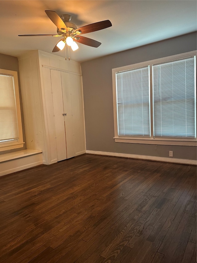 unfurnished bedroom featuring dark hardwood / wood-style floors and ceiling fan