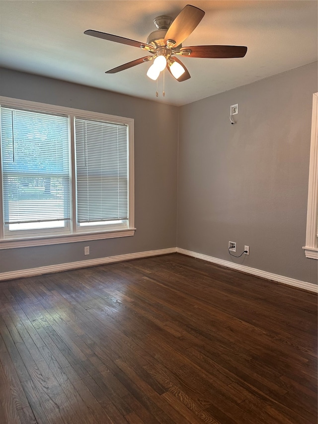 spare room with ceiling fan and dark wood-type flooring