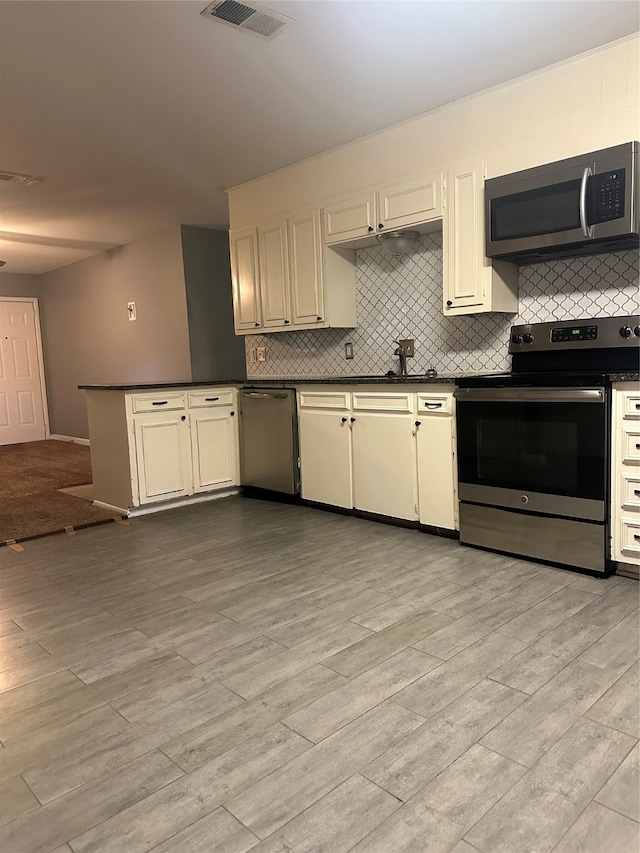 kitchen featuring cream cabinetry, backsplash, stainless steel appliances, and light hardwood / wood-style floors