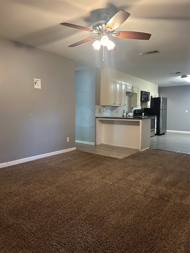 kitchen with electric range, light colored carpet, ceiling fan, tasteful backsplash, and kitchen peninsula