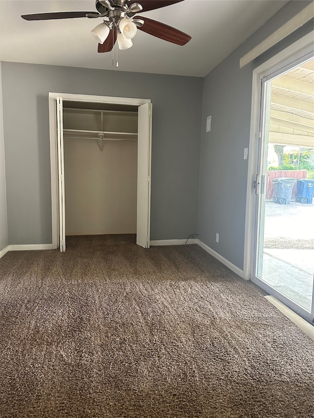 unfurnished bedroom featuring ceiling fan, multiple windows, and carpet floors