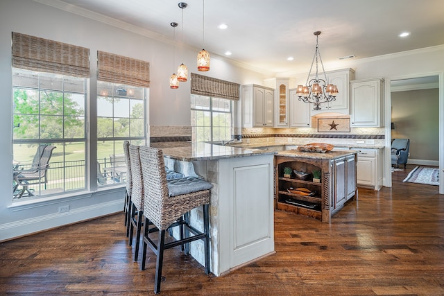 kitchen with kitchen peninsula, light stone countertops, dark hardwood / wood-style flooring, and white cabinets