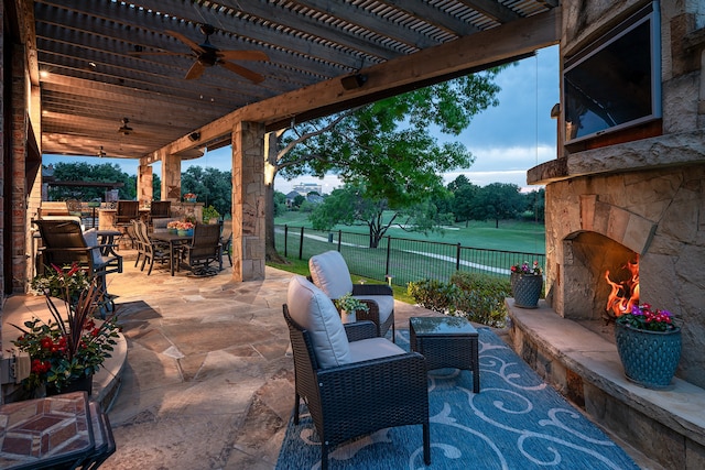 view of patio / terrace with an outdoor living space with a fireplace and ceiling fan