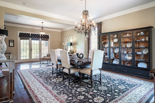 dining area featuring dark hardwood / wood-style flooring, crown molding, french doors, and an inviting chandelier