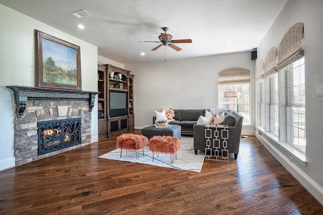 living room featuring a fireplace, dark hardwood / wood-style flooring, and ceiling fan