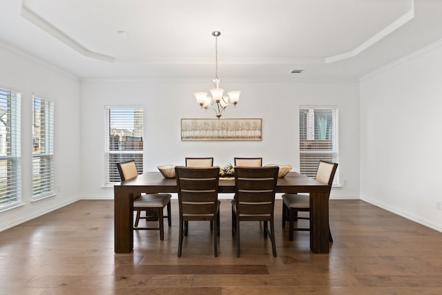 dining room featuring ornamental molding, a tray ceiling, and dark hardwood / wood-style flooring