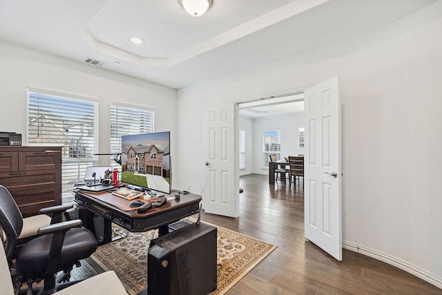 office area featuring a tray ceiling and dark wood-type flooring