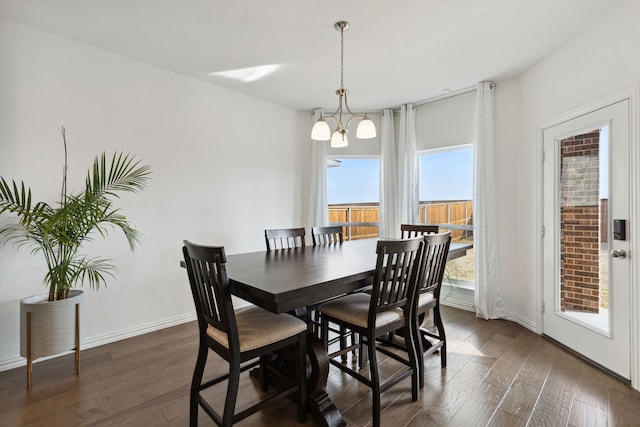 dining space with a notable chandelier and dark hardwood / wood-style floors