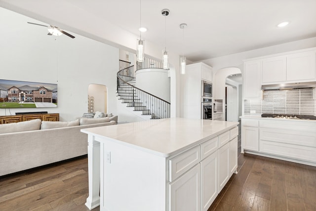 kitchen with a kitchen island, exhaust hood, dark hardwood / wood-style floors, and white cabinets