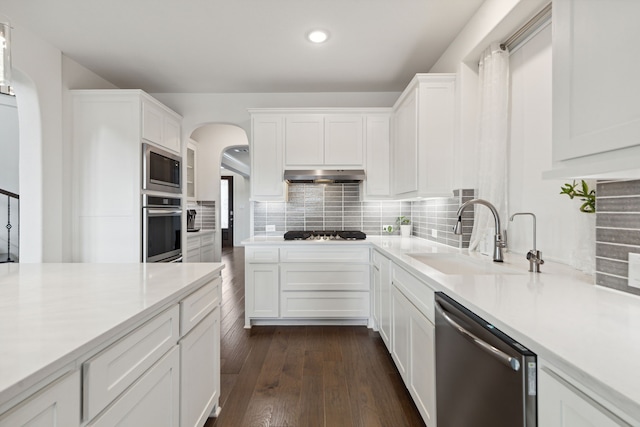 kitchen with decorative backsplash, dark hardwood / wood-style flooring, white cabinetry, sink, and stainless steel appliances