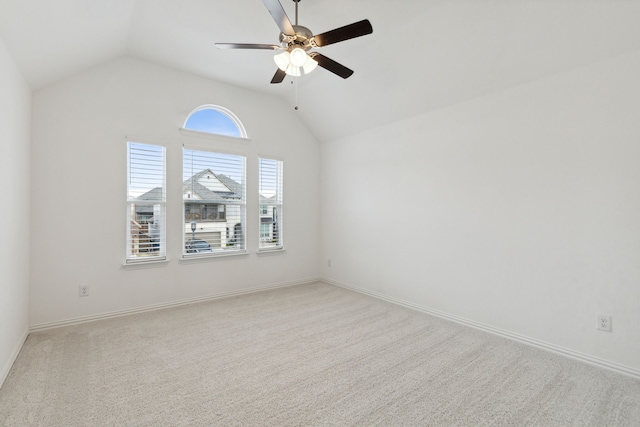 empty room featuring ceiling fan, lofted ceiling, and light colored carpet