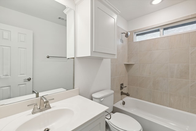 full bathroom featuring toilet, tiled shower / bath, and vanity