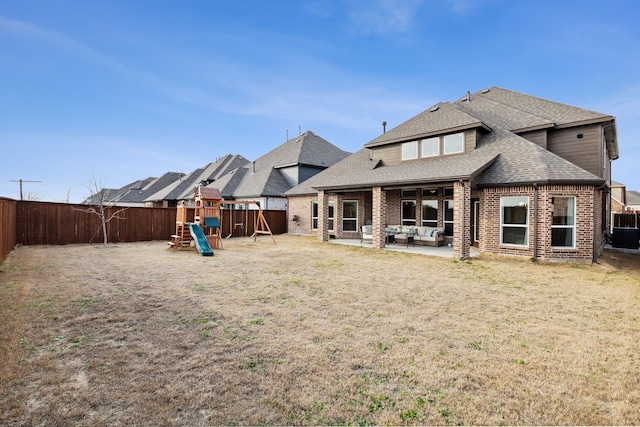 rear view of house with a patio, a playground, and a yard