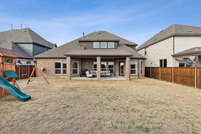 rear view of property featuring a patio area, a playground, and a yard