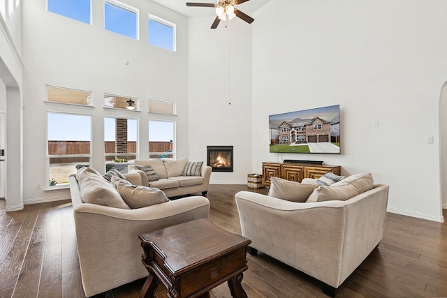 living room featuring dark hardwood / wood-style floors, a wealth of natural light, and a high ceiling