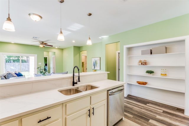 kitchen featuring decorative light fixtures, dishwasher, sink, and light stone countertops