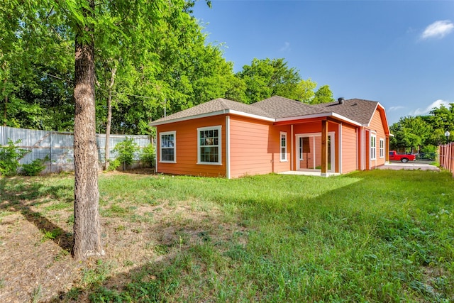 back of property featuring a lawn