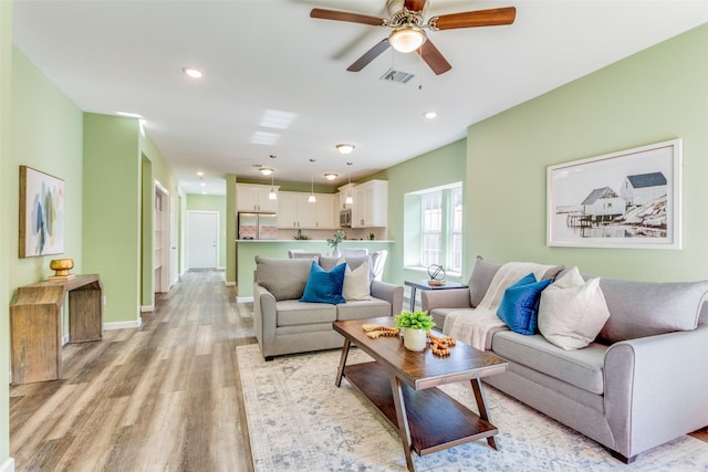 living room featuring ceiling fan and light hardwood / wood-style flooring