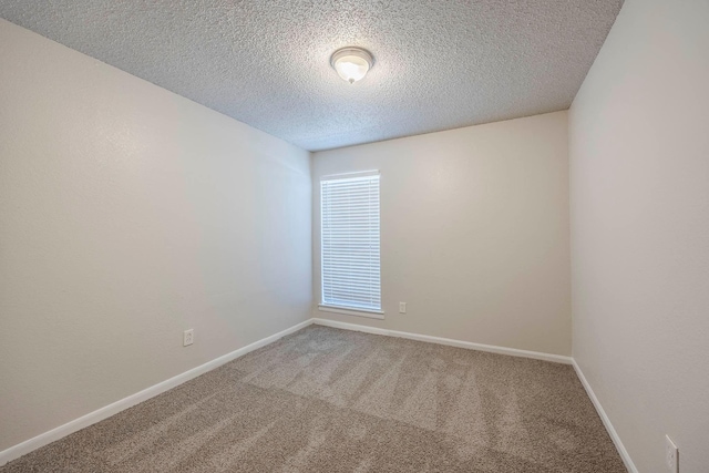 spare room featuring carpet and a textured ceiling