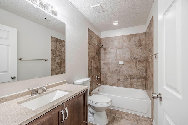 full bathroom featuring tile patterned floors, vanity, a textured ceiling, tiled shower / bath combo, and toilet