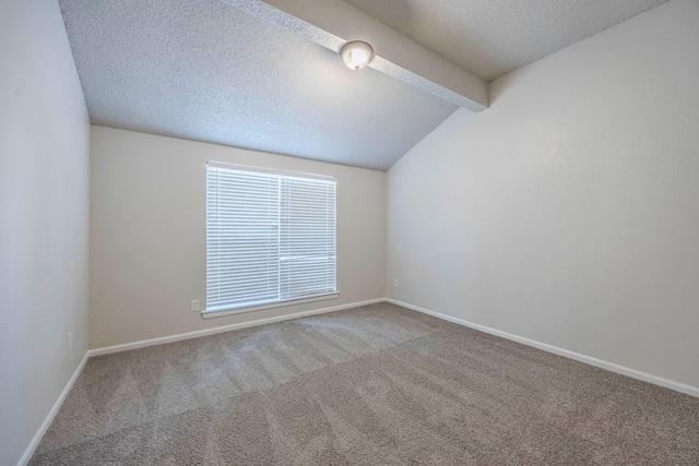 carpeted empty room with a textured ceiling and lofted ceiling with beams