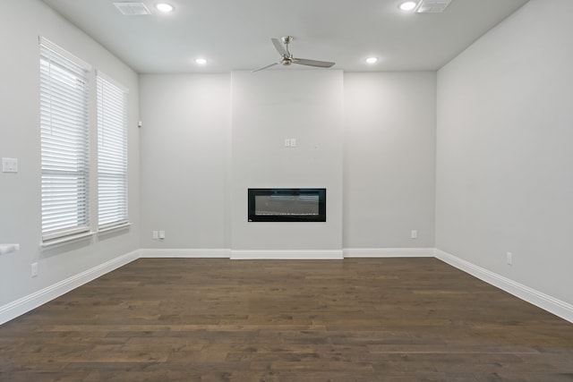 unfurnished living room featuring ceiling fan and dark hardwood / wood-style floors