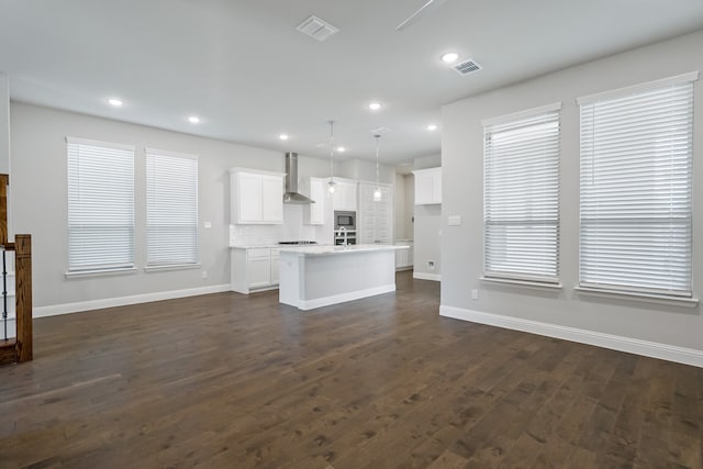 unfurnished living room featuring a healthy amount of sunlight and dark hardwood / wood-style flooring