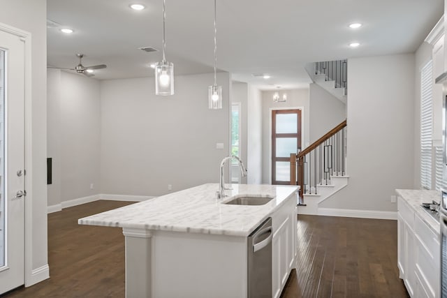 kitchen with white cabinets, an island with sink, decorative light fixtures, and sink