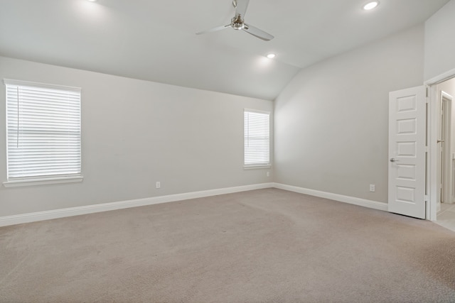 carpeted empty room featuring lofted ceiling, ceiling fan, and a wealth of natural light