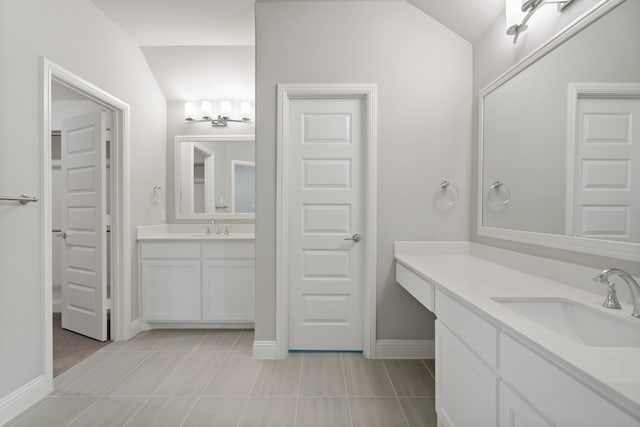 bathroom with lofted ceiling, vanity, and tile patterned floors