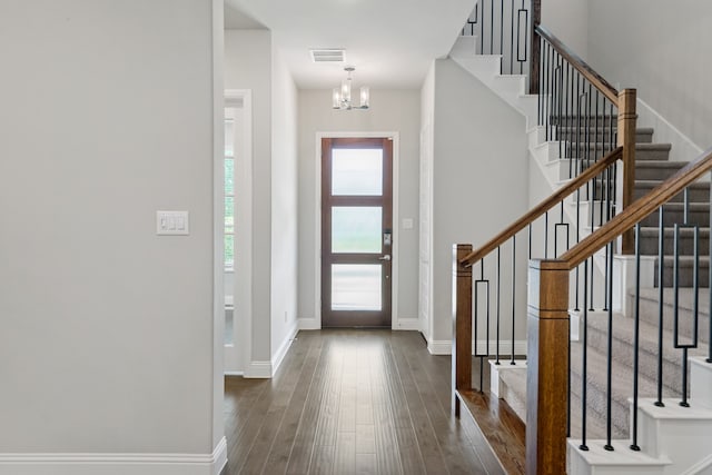 foyer entrance featuring an inviting chandelier and dark hardwood / wood-style flooring