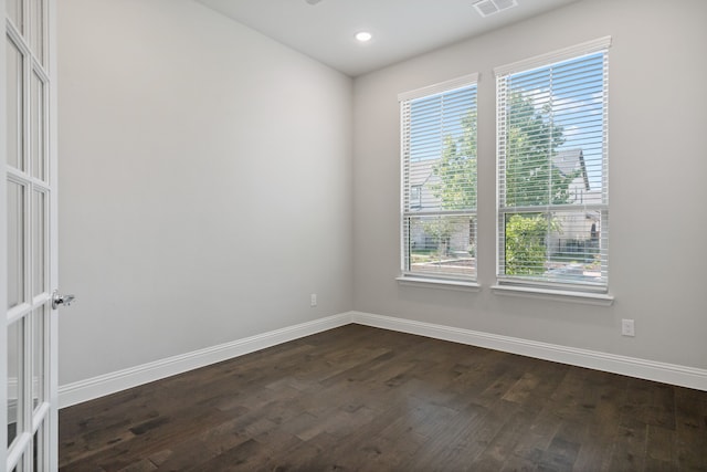 unfurnished room with a healthy amount of sunlight and dark wood-type flooring