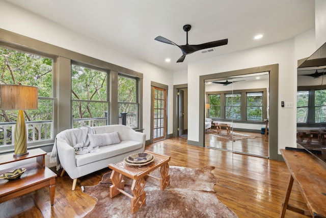 living room with light wood-type flooring and ceiling fan