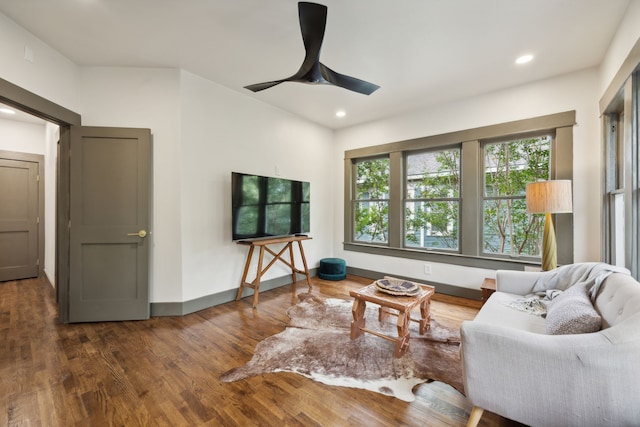 living room featuring ceiling fan and dark hardwood / wood-style flooring