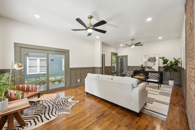 living room with a healthy amount of sunlight, dark wood-type flooring, and ceiling fan